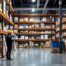 A photograph of a well-organized warehouse or storage room featuring neatly arranged shelves stocked with products